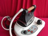 a white and black steam iron on a red surface