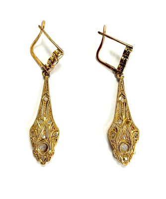 pair of gold tone earrings with black and white stones on them