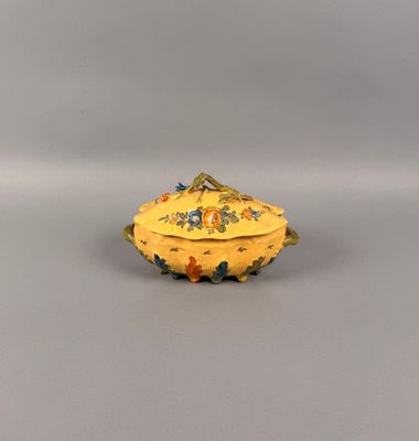 une petite boîte jaune décorée de fleurs, posée sur une table