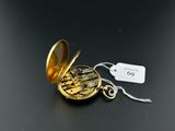 a small gold pocket watch with a tag attached to it