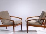 pair of mid - century danish lounge chairs with upholstered cushions