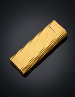 a gold lighter sitting on top of a black surface