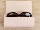 chanel sunglasses in a case on a table with a white card