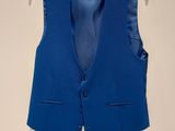 a blue vest hanging on a hanger on a wall