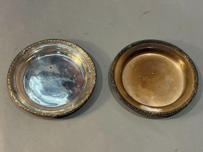 pair of silver plated bowls with a gold rim on a white surface