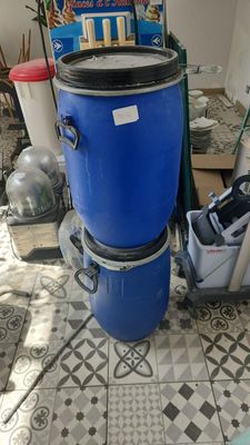 a blue trash can sitting on the floor next to a vacuum