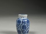 blue and white vase with a lid and a flower design on it