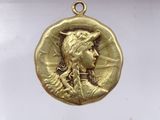 a close up of a gold medal with a woman ' s face on it