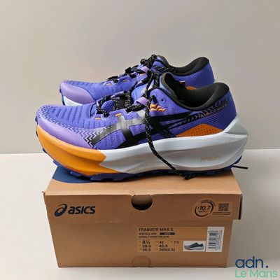 purple and orange running shoes on top of a box on a table