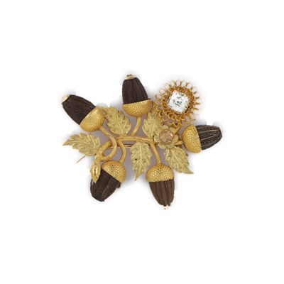 une broche en or représentant des fleurs et des feuilles sur fond blanc