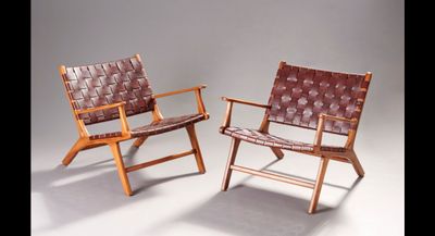 two brown leather chairs sitting next to each other on a white surface