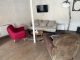 un salon équipé d'un canapé, d'un fauteuil et d'une télévision