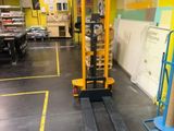 a forklift in the middle of a room with a yellow wall