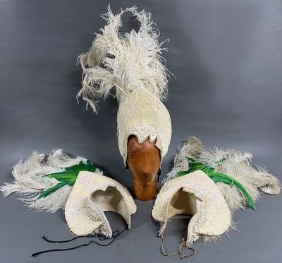 une paire de chapeaux blancs et verts ornés de plumes sur le dessus