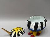 a black and white bowl and a yellow and white umbrella