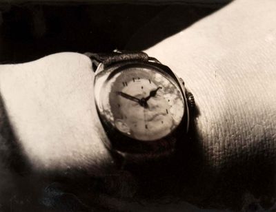 a black and white photo of a wrist with a watch on it