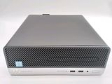 the front of a silver hp desktop computer on a white surface