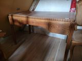 a wooden desk with two chairs and a chair in the corner