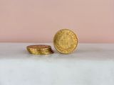 a stack of gold coins sitting on top of a white table