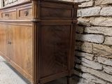 a very old wooden dresser in front of a stone wall