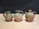 three vases are sitting on a table with a black background