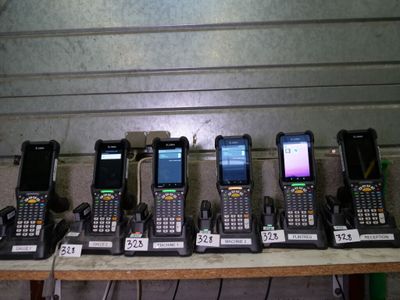 several cell phones are lined up on a table in front of a wall