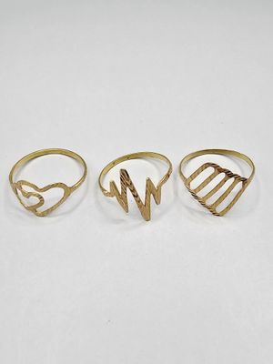 three gold rings, one with a heart and the other with a letter w