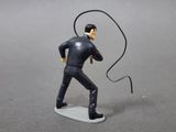 a figurine of a man in a suit with a whip