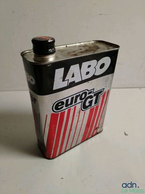 a can of soda sitting on a table next to a white wall