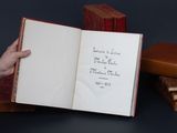une personne tenant un livre ouvert sur lequel figurent des inscriptions