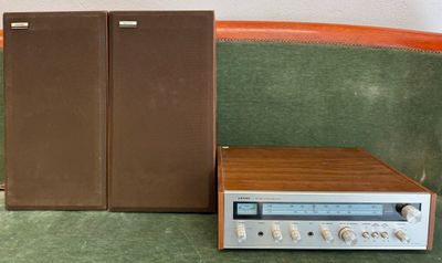 a radio sitting on a green couch next to a brown cabinet