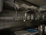 a kitchen with a lot of bottles and glasses on the counter