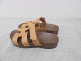 leather sandals with straps and studs on them on a white surface
