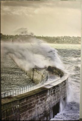 une photo montrant une grande vague déferlant sur un mur