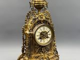 an antique clock sitting on top of a table next to a gray wall