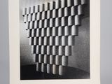 a black and white photo of a wall made out of cylinders