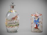 two glass bottles with paintings on them sitting next to each other