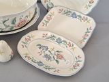 a table with a variety of plates and bowls and salt and pepper shakers