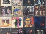 various album covers are arranged on a wall in a room
