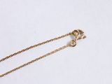 a close up of a gold necklace with a chain on a white surface