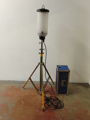 une lampe posée sur un trépied à côté d'un haut-parleur