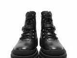 une paire de bottes en cuir noir sur fond blanc