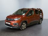 La camionnette rouge est garée dans une grande pièce au sol noir.