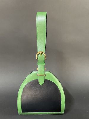 a green and black handbag with a gold buckle