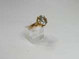 an image of a gold ring with a blue topaz stone