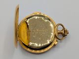 a gold pocket watch on a white surface