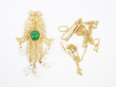 two gold and green brooches with pearls on them