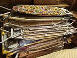 une pile de tables à repasser, surmontée d'une planche de surf