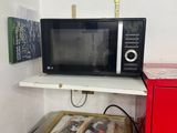 a microwave sitting on top of a shelf next to a red refrigerator