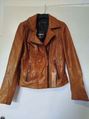 une veste en cuir marron suspendue à un cintre dans une pièce